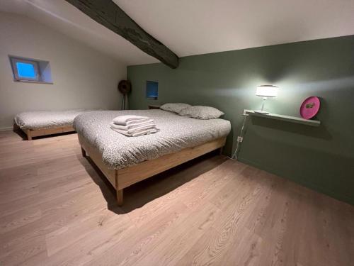 - une chambre avec 2 lits et un mur vert dans l'établissement Appartement privé rose, à Vinzieux