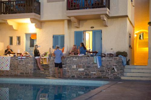 a group of people standing next to a swimming pool at Porto Sisi Hotel Apartments in Sissi