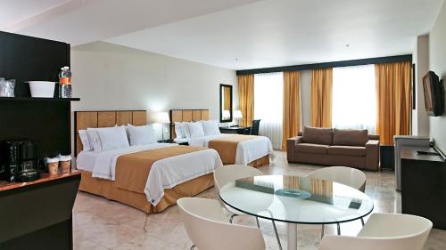 a hotel room with two beds and a table at Holiday Inn Express Ciudad Del Carmen by IHG in Ciudad del Carmen