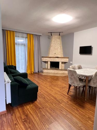 a living room with a couch and a table and a fireplace at Hillstory Borjomi tba in Tsemi