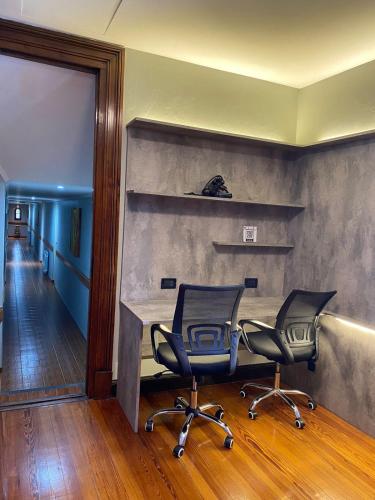 two chairs in a room with a desk and a hallway at Hotel Boutique Calash in Mar del Plata
