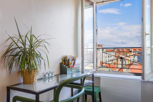 un bureau avec une plante en pot à côté d'une fenêtre dans l'établissement Lyon Premium- Nid Cosy, à Lyon