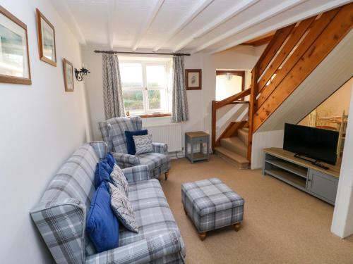 a living room with a couch and a television at Stable Cottage in Haverfordwest