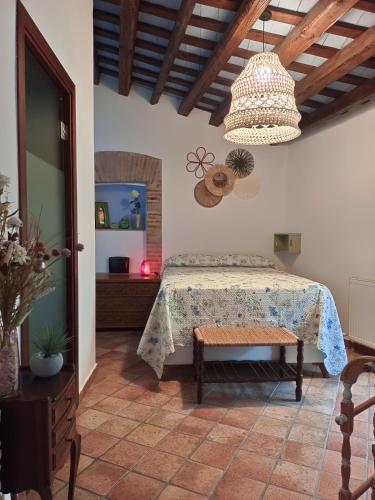 a bedroom with a bed and a chandelier at Casa Blava in Castelló d'Empúries