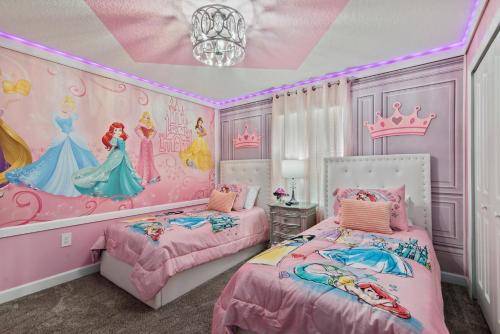 a disney princess bedroom with two beds and a chandelier at Lakeview 5BR with Game Room and Pool, Near Disney in Kissimmee