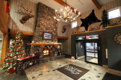 a lobby with a christmas tree and a fireplace at C'mon Inn Missoula in Missoula