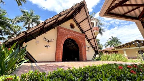a building with an archway in a yard at Tequendama Hotel Campestre Villavicencio in Villavicencio