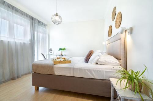a bedroom with a large bed with white walls at Chania Urban Living - Live like a local in Chania Town