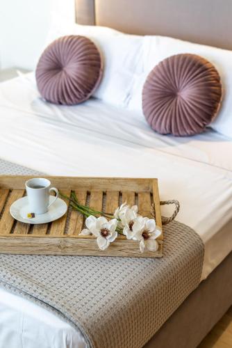 a tray with a coffee cup and flowers on a bed at Chania Urban Living - Live like a local in Chania Town