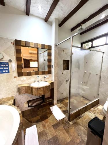 a bathroom with a sink and a shower at Tequendama Hotel Campestre Villavicencio in Villavicencio