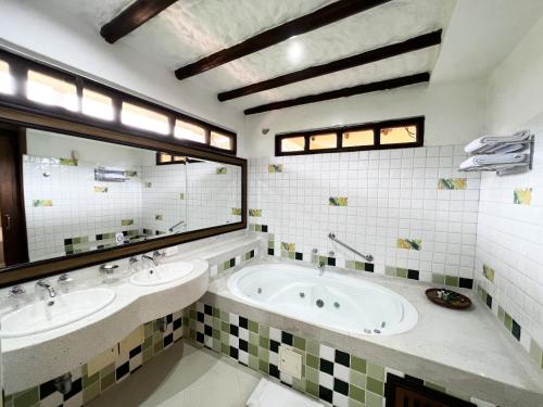a bathroom with two sinks and a large mirror at Tequendama Hotel Campestre Villavicencio in Villavicencio