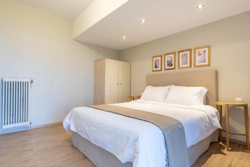 a bedroom with a large bed with white sheets at Chania Urban Living - Live like a local in Chania Town