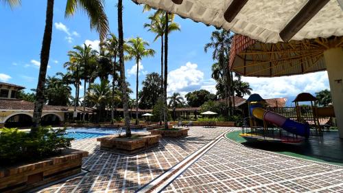 a resort pool with a slide and a playground at Tequendama Hotel Campestre Villavicencio in Villavicencio