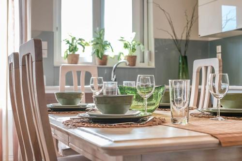a dining room table with glasses and plates on it at Chania Urban Living - Live like a local in Chania Town