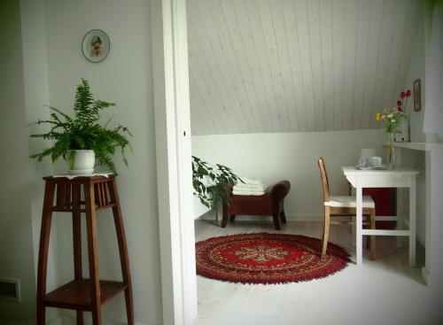 a room with a table and a chair and a table and a rug at Alpakarium, Hodowla alpak & pensjonat in Stara Kornica