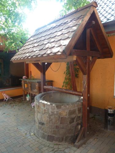 a building with a roof on top of a stone tub at Landgasthof Deinert in Parchen