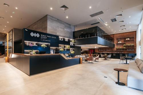 a restaurant with a counter and tables and chairs at WTC Goiânia Stay & Hotel by Atlantica in Goiânia