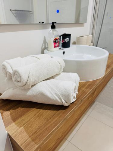 a pile of towels sitting on a counter in a bathroom at Paradise Garajau in Garajau