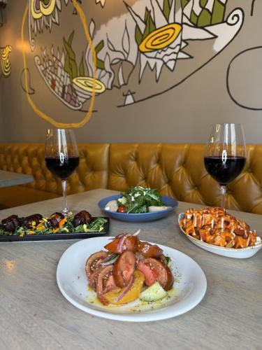 a table with plates of food and two glasses of wine at Warwick San Francisco in San Francisco