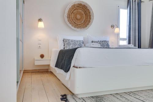 a white bedroom with a white bed and a mirror at Chania Urban Living - Live like a local in Chania Town