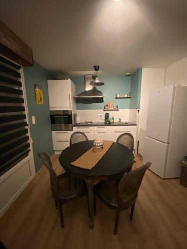 une cuisine avec une table et des chaises dans une pièce dans l'établissement Le Kosy des Toms, à Bertrichamps