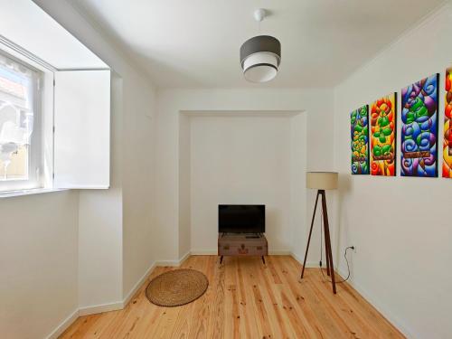 a living room with a tv and a window at Carnide 1913 E - 1BR apt in Lisbon