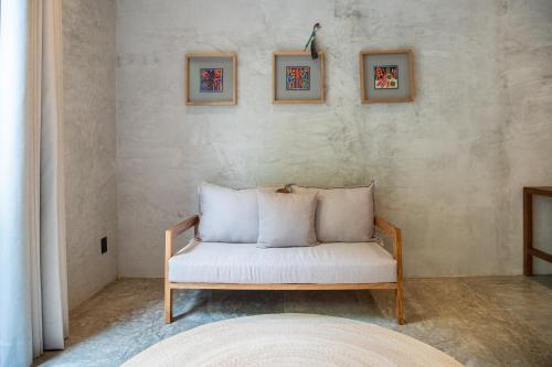 a white couch in a room with three pictures on the wall at Witari Hotel Boutique in San Francisco