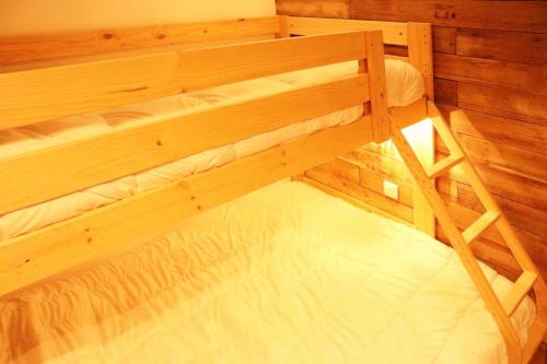Cette chambre comprend un grand lit superposé en bois. dans l'établissement Residence La Combe D Or - Appartement en résidence de standing MAE-0814, aux Orres