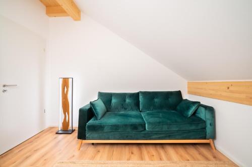 a green couch in a living room with a lamp at LIBORIA I Traumhafte Ferienwohnung in Aidling am Riegsee in Riegsee