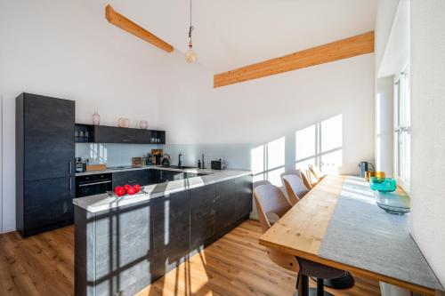 a kitchen with a wooden table and a dining room at LIBORIA I Traumhafte Ferienwohnung in Aidling am Riegsee in Riegsee