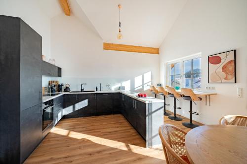 a kitchen with a table and a dining room at LIBORIA I Traumhafte Ferienwohnung in Aidling am Riegsee in Riegsee