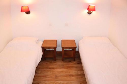 deux lits dans une pièce avec une table entre eux dans l'établissement Résidence Les Eglantines - 2 pièces 6 personnes place centrale les Orres 1800 MAE-6734, aux Orres