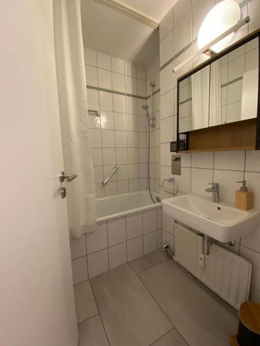 a bathroom with a sink and a bath tub at Fewo Taunusblick mit Pool in Lahnstein