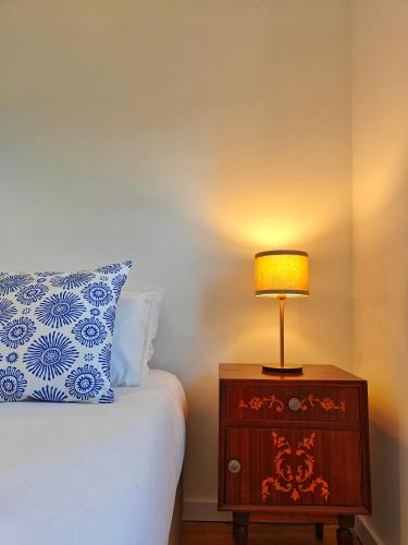 a lamp on a night stand next to a bed at The Ceramic - 2BR apt in Lisbon