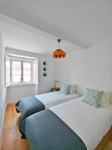 a bedroom with two beds and a window at The Ceramic - 2BR apt in Lisbon