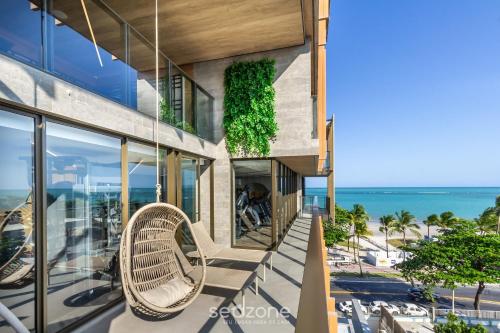 an exterior view of a building with benches and the ocean at NWTs - Estúdios em Prédio com Vista Mar in Maceió