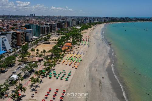 an aerial view of a beach with chairs and umbrellas at NWTs - Estúdios em Prédio com Vista Mar in Maceió