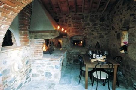 a stone room with a table and a fireplace at Borgo Nuovo San Martino in Ambra