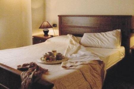 a bed with a plate of food on it at Borgo Nuovo San Martino in Ambra