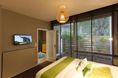 um quarto com uma cama e uma grande janela em Aparthotel Liège em Liège