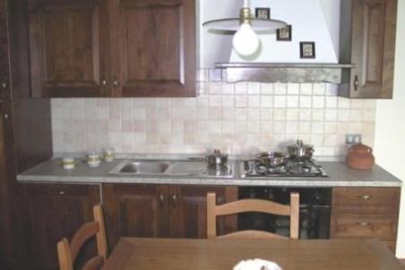 a kitchen with a sink and a stove and a table at Borgo Nuovo San Martino in Ambra