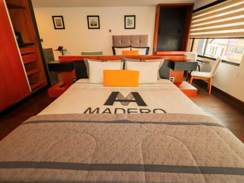 a master bedroom with a large bed with a mamedo blanket at Madero Hotel & Suites in La Paz