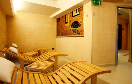 a room with three wooden benches and a wall at 'A Nuciara Park Hotel & Spa in Furci Siculo