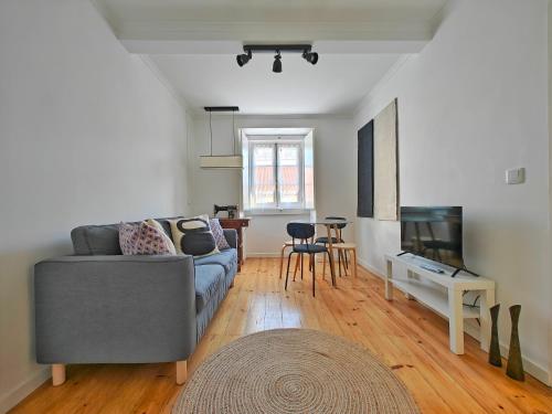 a living room with a couch and a television at The Fabric - 2BR apt in Lisbon