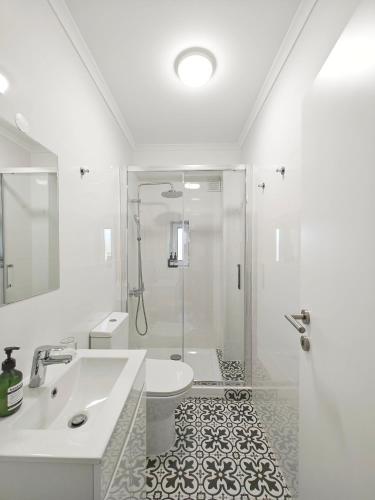 a bathroom with a shower and a sink and a toilet at The Fabric - 2BR apt in Lisbon