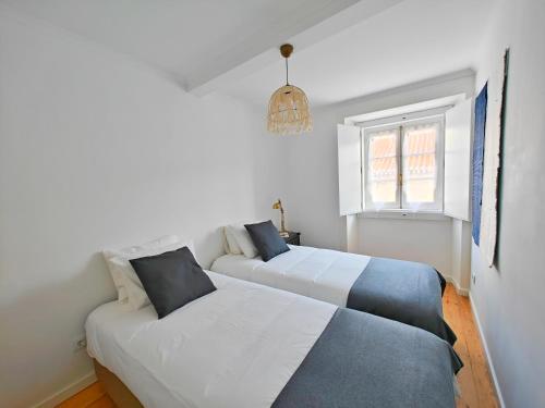 a bedroom with two beds and a window at The Fabric - 2BR apt in Lisbon