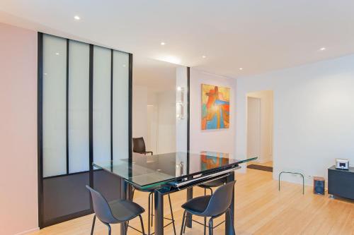 une table et des chaises en verre dans une pièce dans l'établissement large pleasant studio alcove in center, à Paris