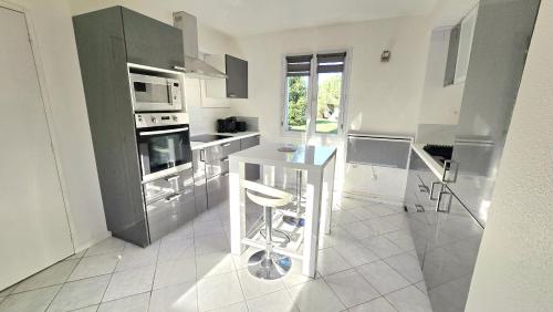 une cuisine avec des appareils en acier inoxydable et un comptoir dans l'établissement Maison 2 chambres-L'Agapanthe, à Ozillac