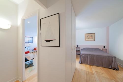 une chambre avec un lit et un tableau au mur dans l'établissement large pleasant studio alcove in center, à Paris