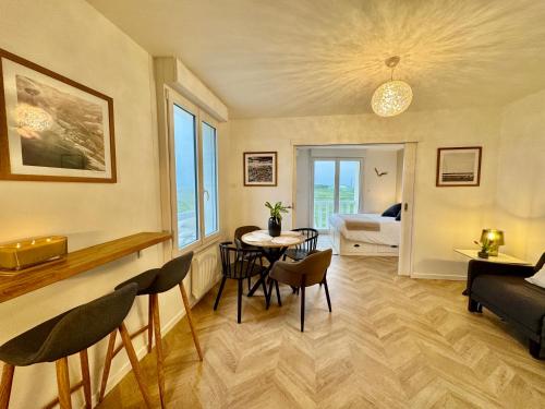 un salon avec une table et des chaises et une chambre dans l'établissement Le Petit Porspaul T2 vue mer et proximité plage, à Lampaul-Plouarzel